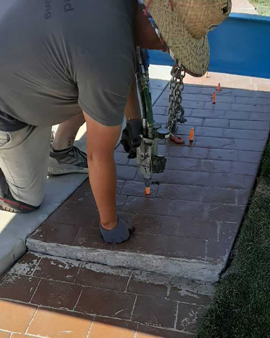 Crewman injecting expanding foam to lift a concrete walkway