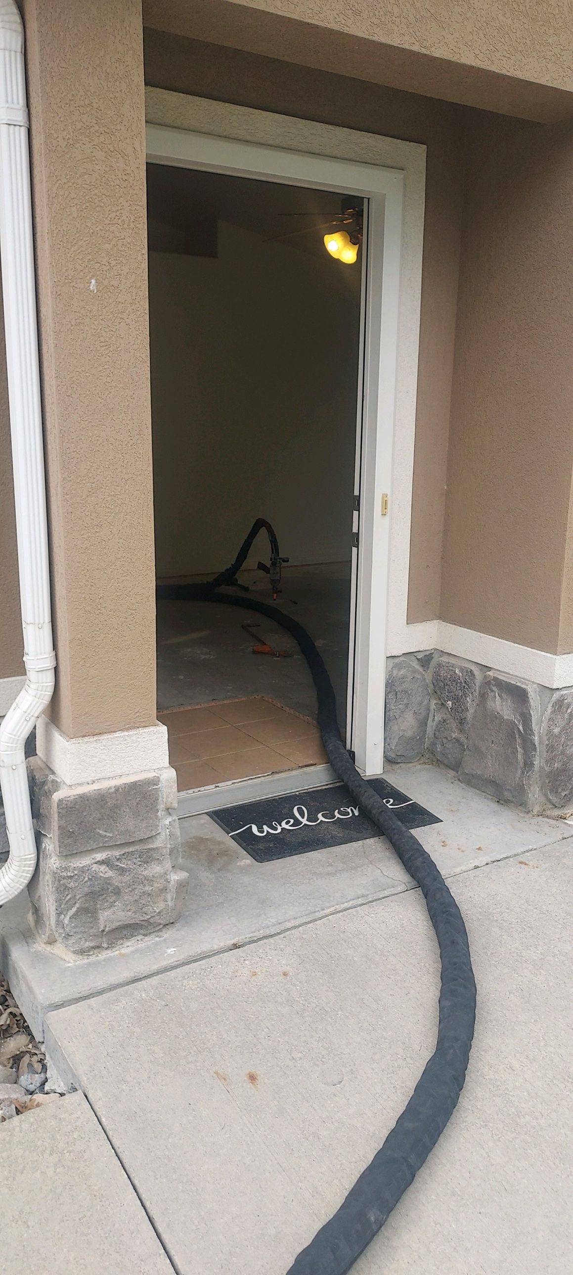 Poly-Lift foam hose running through a home's front door to lift interior concrete