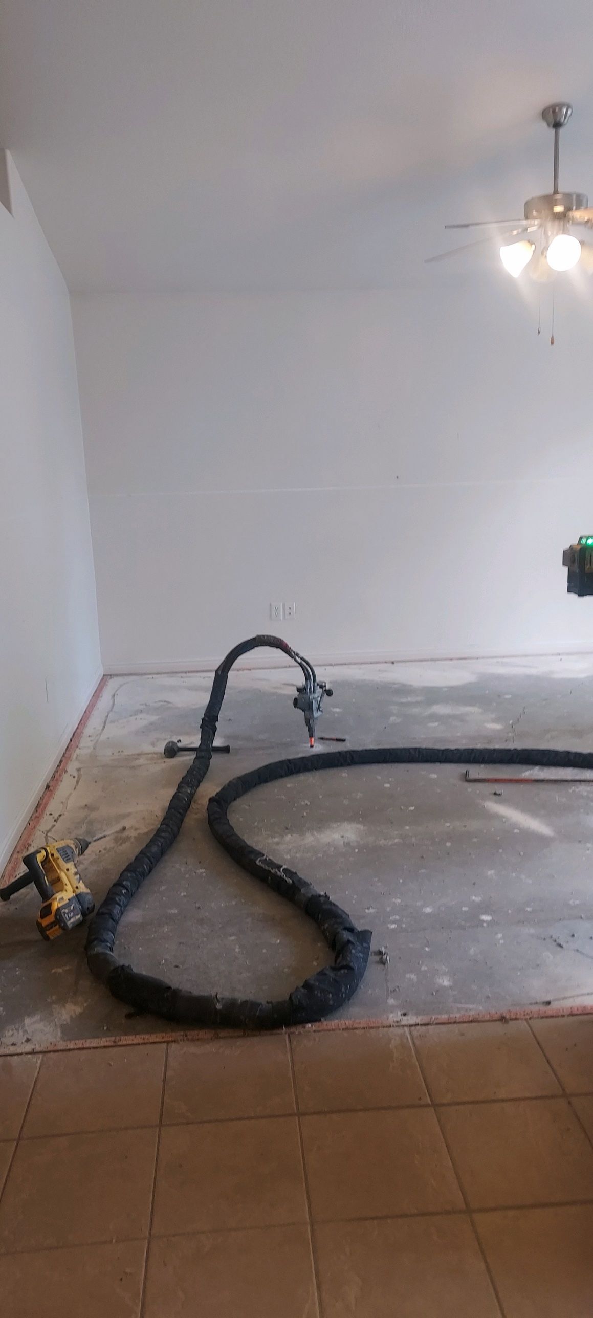 Poly-Lift foam-lifting an interior floor where tile meets bare concrete